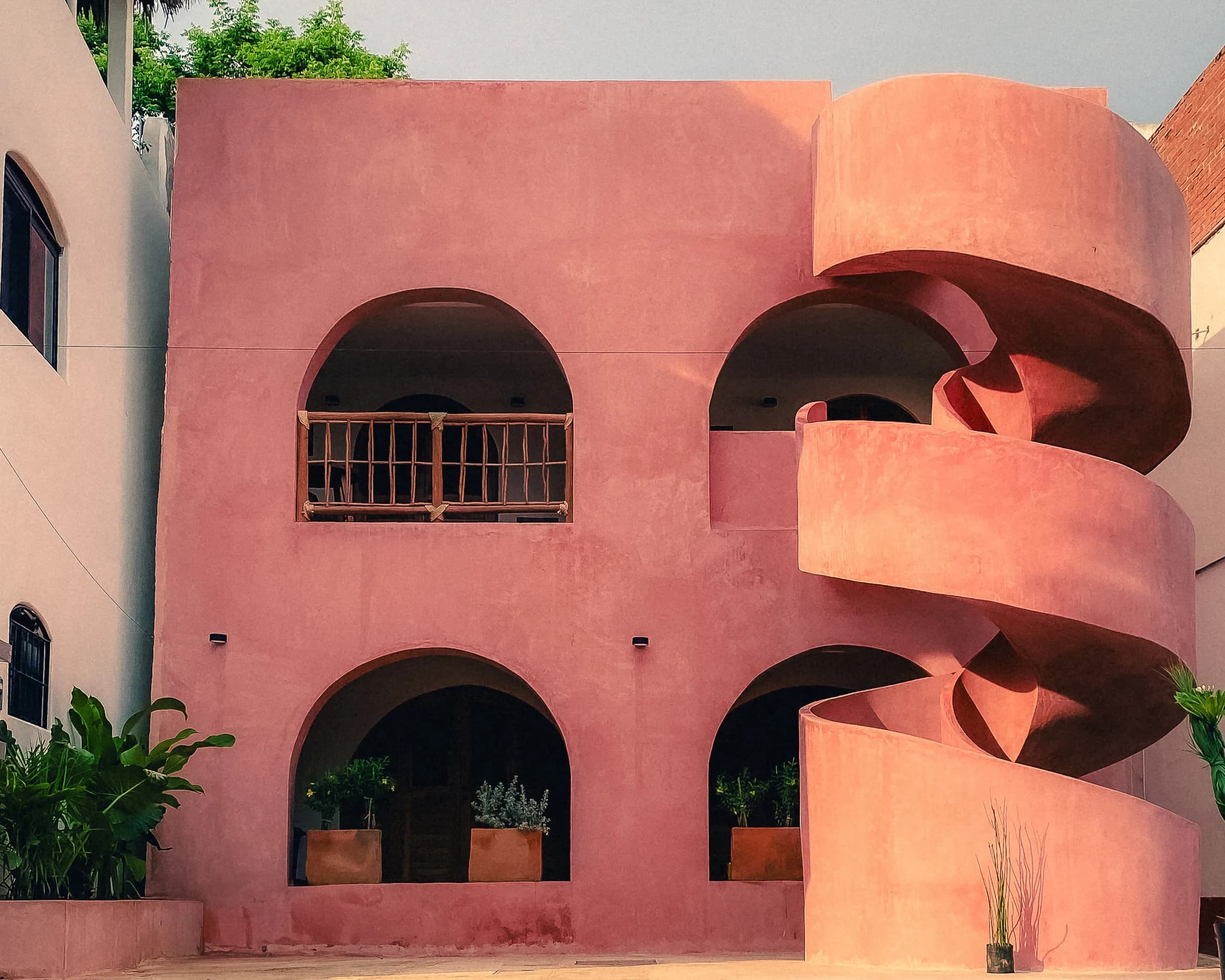 Fachada rosa de Casa Amapa con escalera caracol