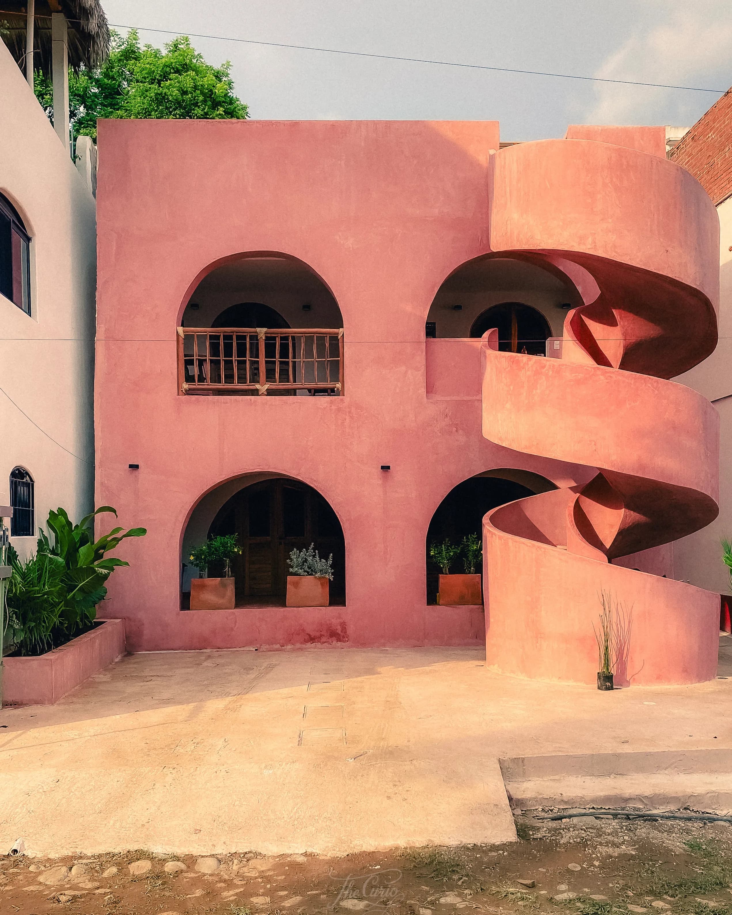Fachada rosa de Casa Amapa con escalera caracol